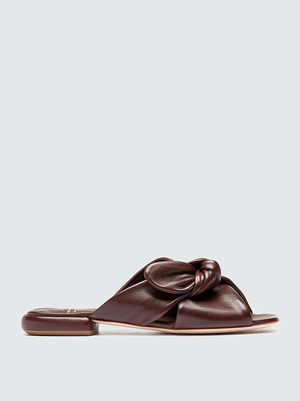 Burgundy flat sole pair arranged together on a neutral ground