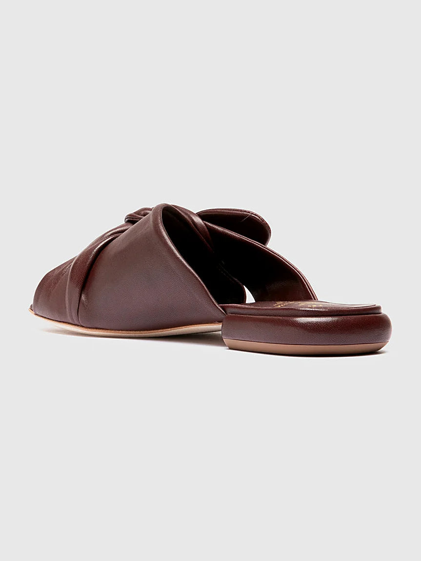 Burgundy flat sole shown from the side on a plain background