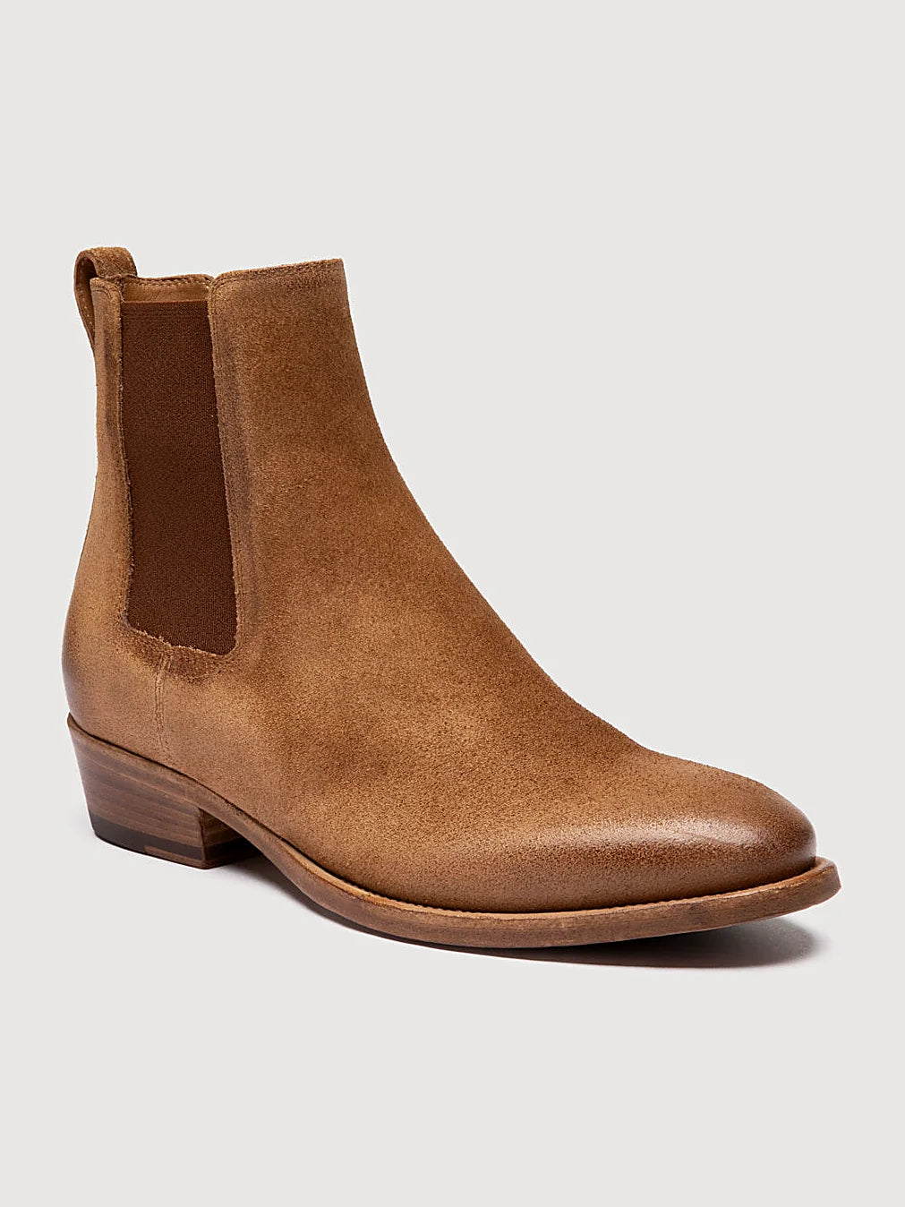 Brown chelsea boots pair arranged together on a neutral ground