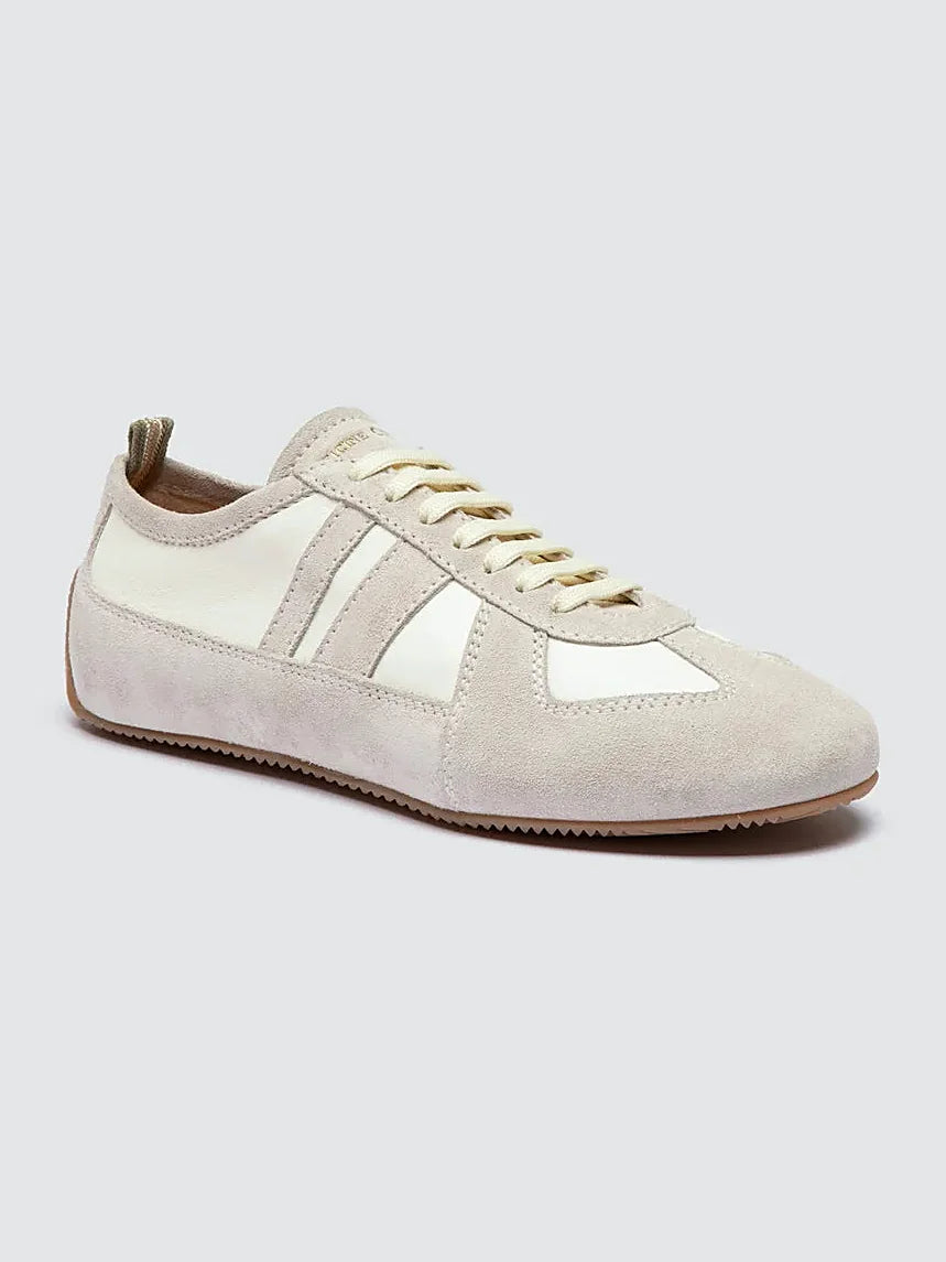 White leather sneakers seen at an angle showing the toe