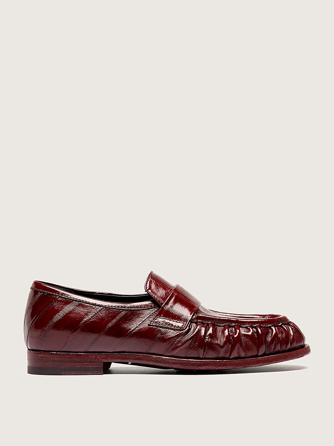 Burgundy rubber-injected sole pair arranged together on a neutral ground